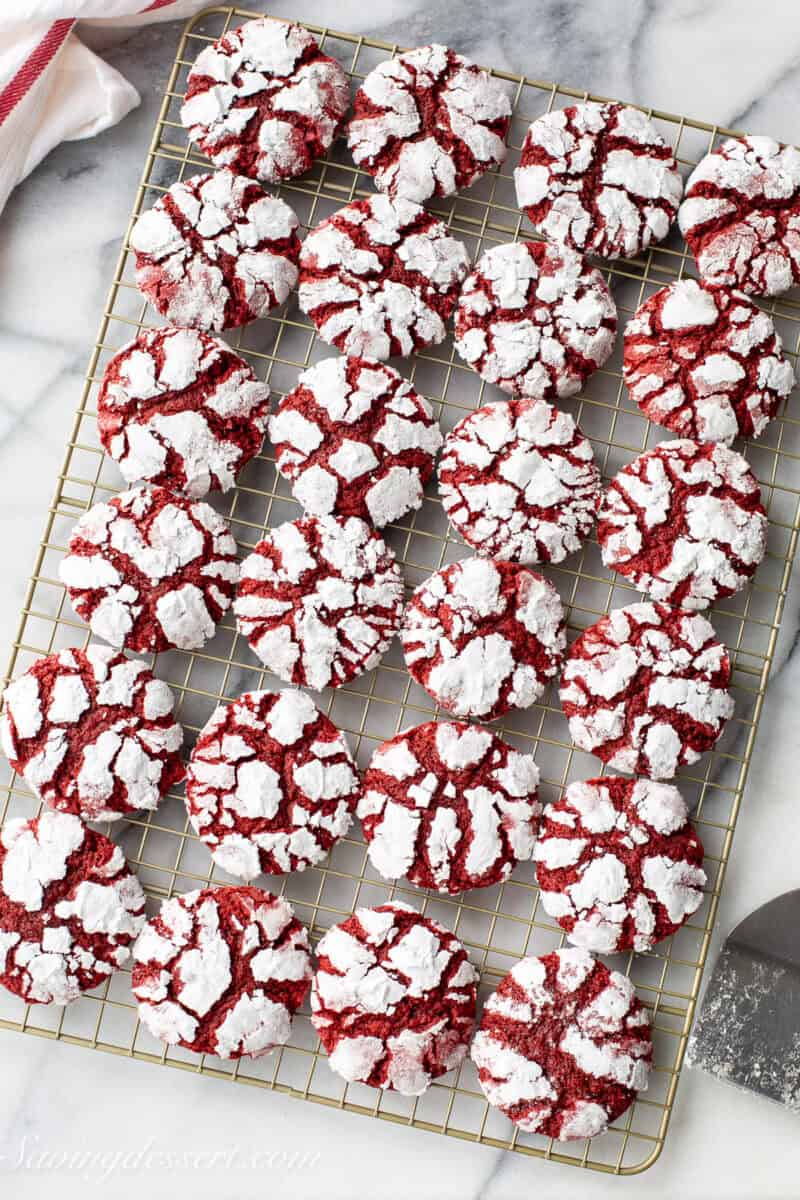 A cooling rack filled with red velvet crinkle cookies.