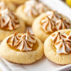 A small platter with lemon meringue cookies with toasted meringue swirls on top.