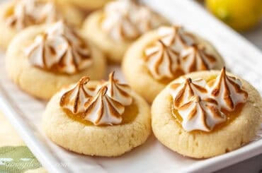 A small platter with lemon meringue cookies with toasted meringue swirls on top.