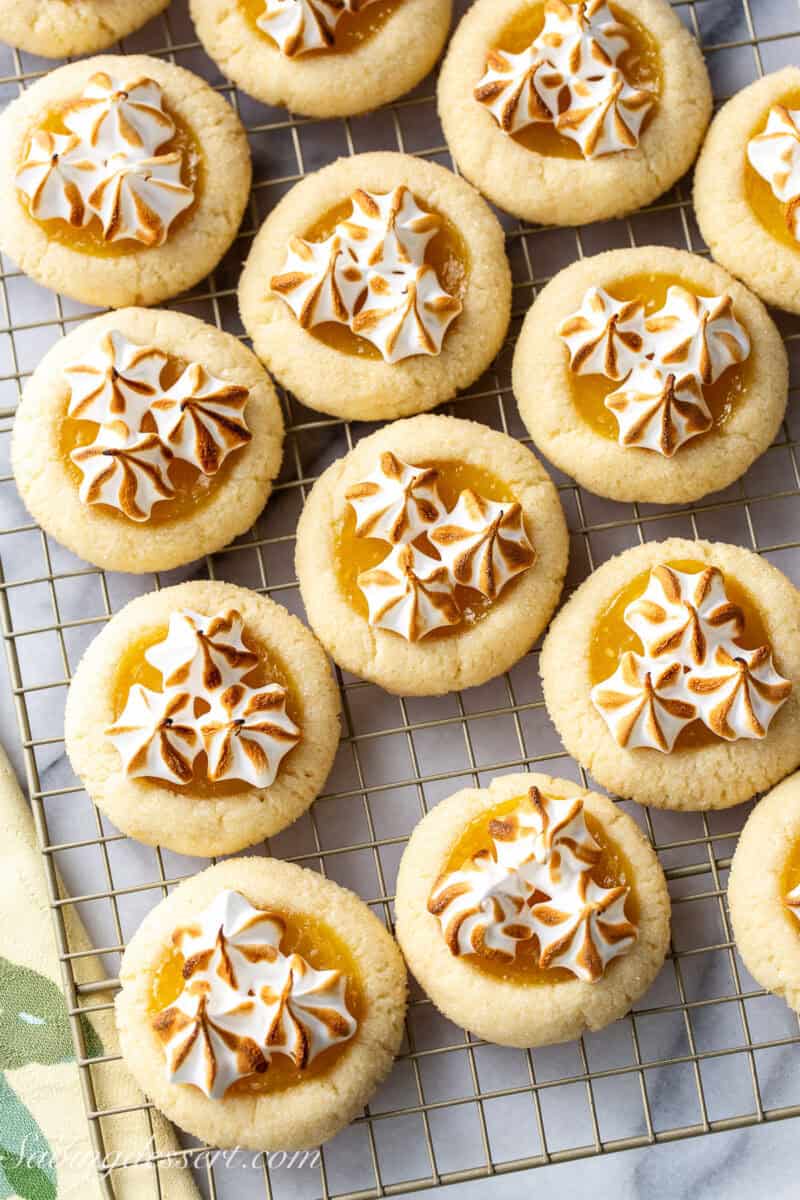 An overhead view of a cooling rack filled with lemon pie cookies topped with toasted meringue.