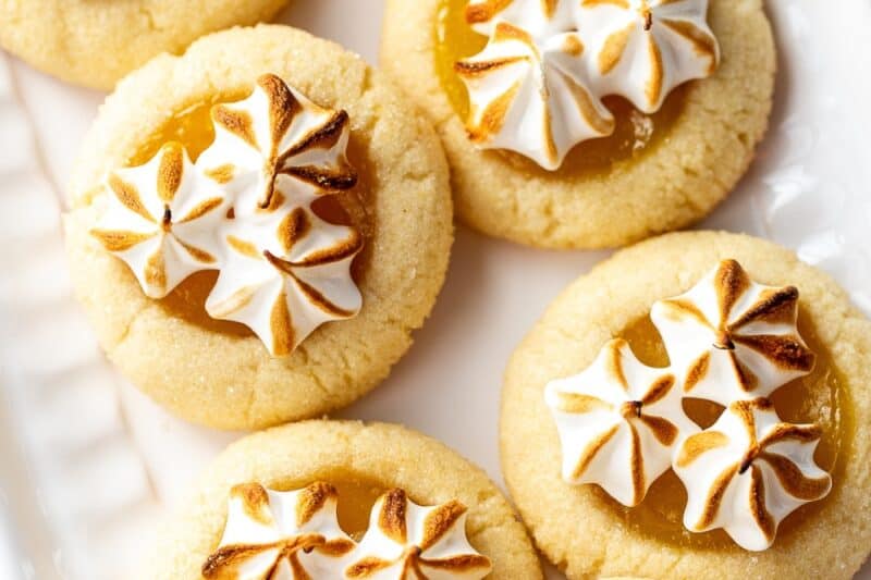 An overhead view of a platter filled with lemon meringue pie cookies with toasted meringue on top.