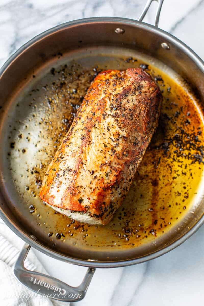 A skillet with a browned pork loin roast.