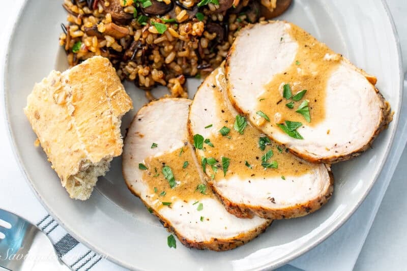 A closeup of three slices of pork with a golden sauce over the top.