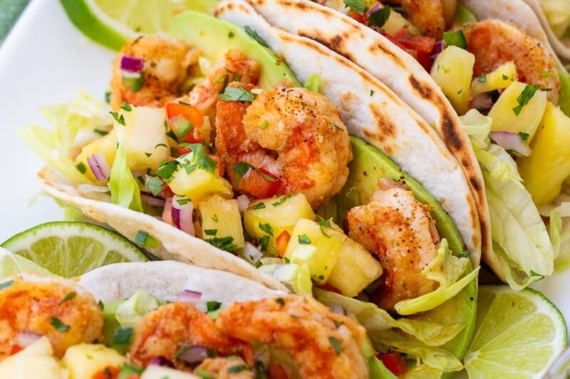 Shrimp Tacos on a platter topped with pineapple salsa.