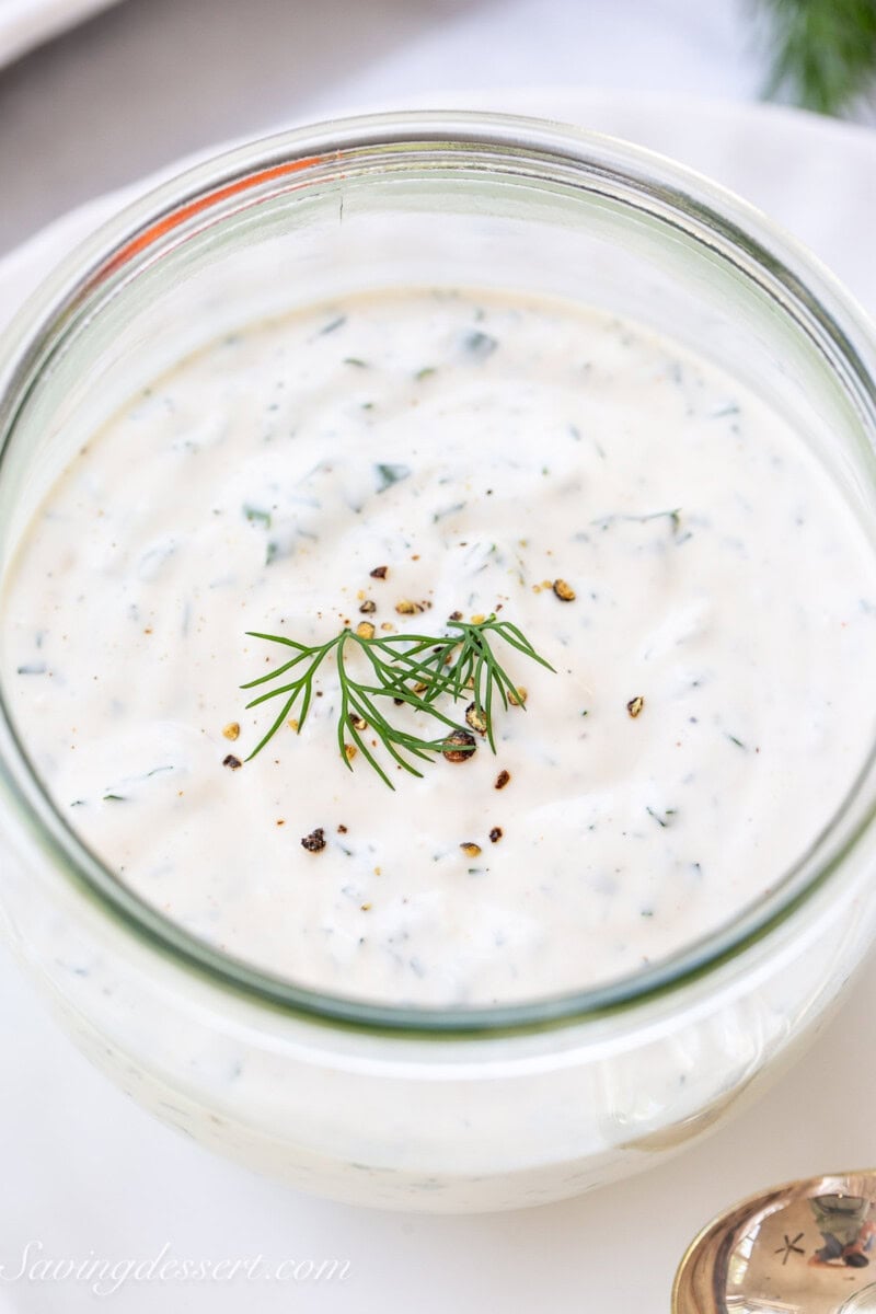 A closeup of a jar of homemade ranch dressing.