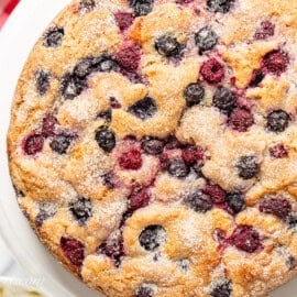 An overhead photo of a single layered berry packed cake with a crunchy sugary top.