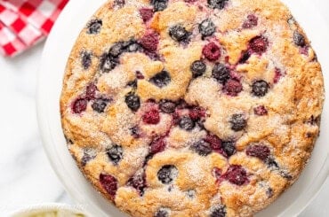 An overhead photo of a single layered berry packed cake with a crunchy sugary top.