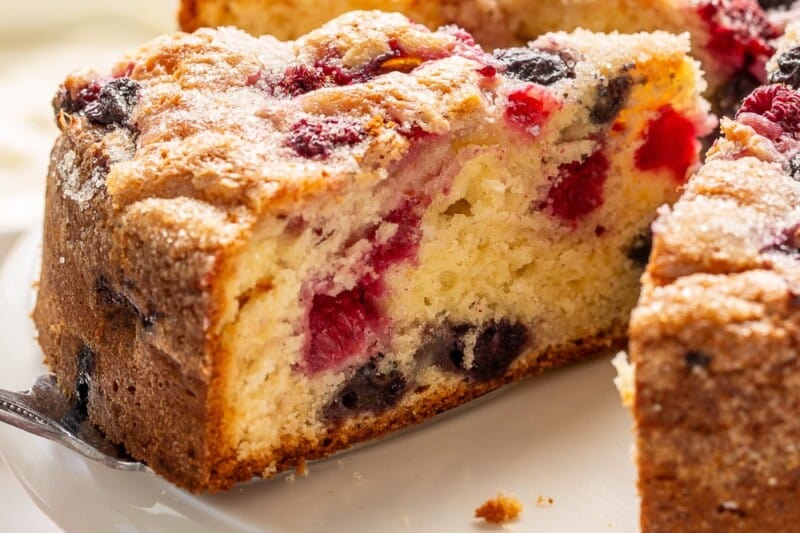A side view of a sliced red white and blue cake on a cake stand.