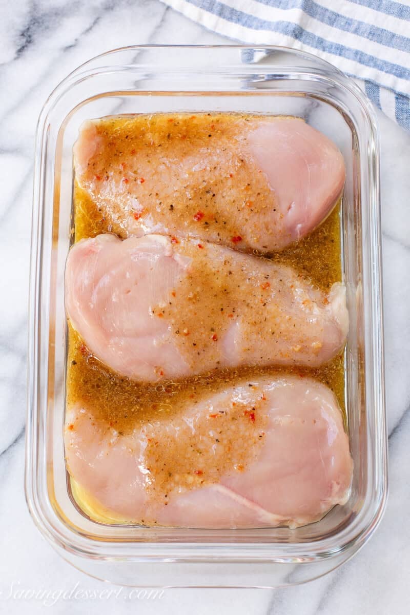 Chicken breasts being marinated in Italian dressing.