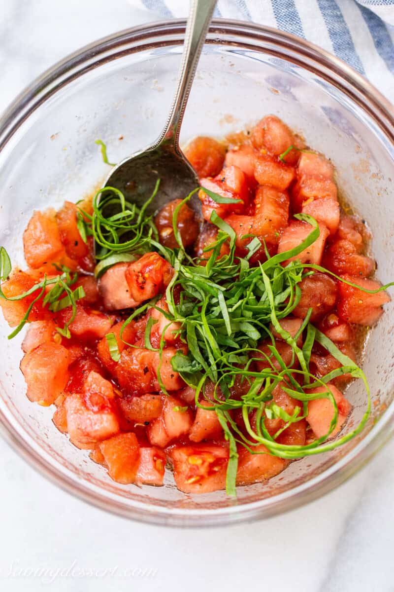 A bowl of tomato bruschetta topping with fresh basil.