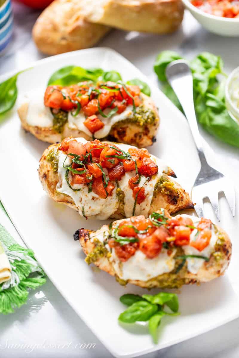 Chicken breasts topped with cheese and tomatoes.