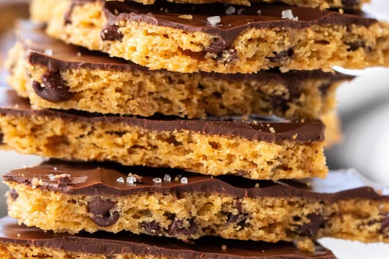 A side view of a stack of chocolate chip cookie bark topped with dark chocolate and sea salt.