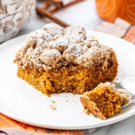 A square piece of pumpkin crumb cake with a bite cut off with a fork.