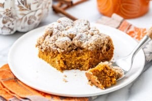 A square piece of pumpkin crumb cake with a bite cut off with a fork.