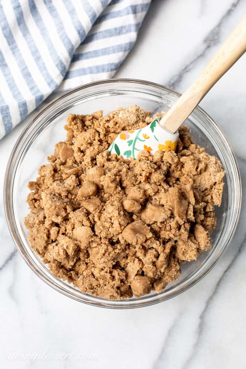 A bowl of crumb batter to be sprinkled on top of a pumpkin cake.